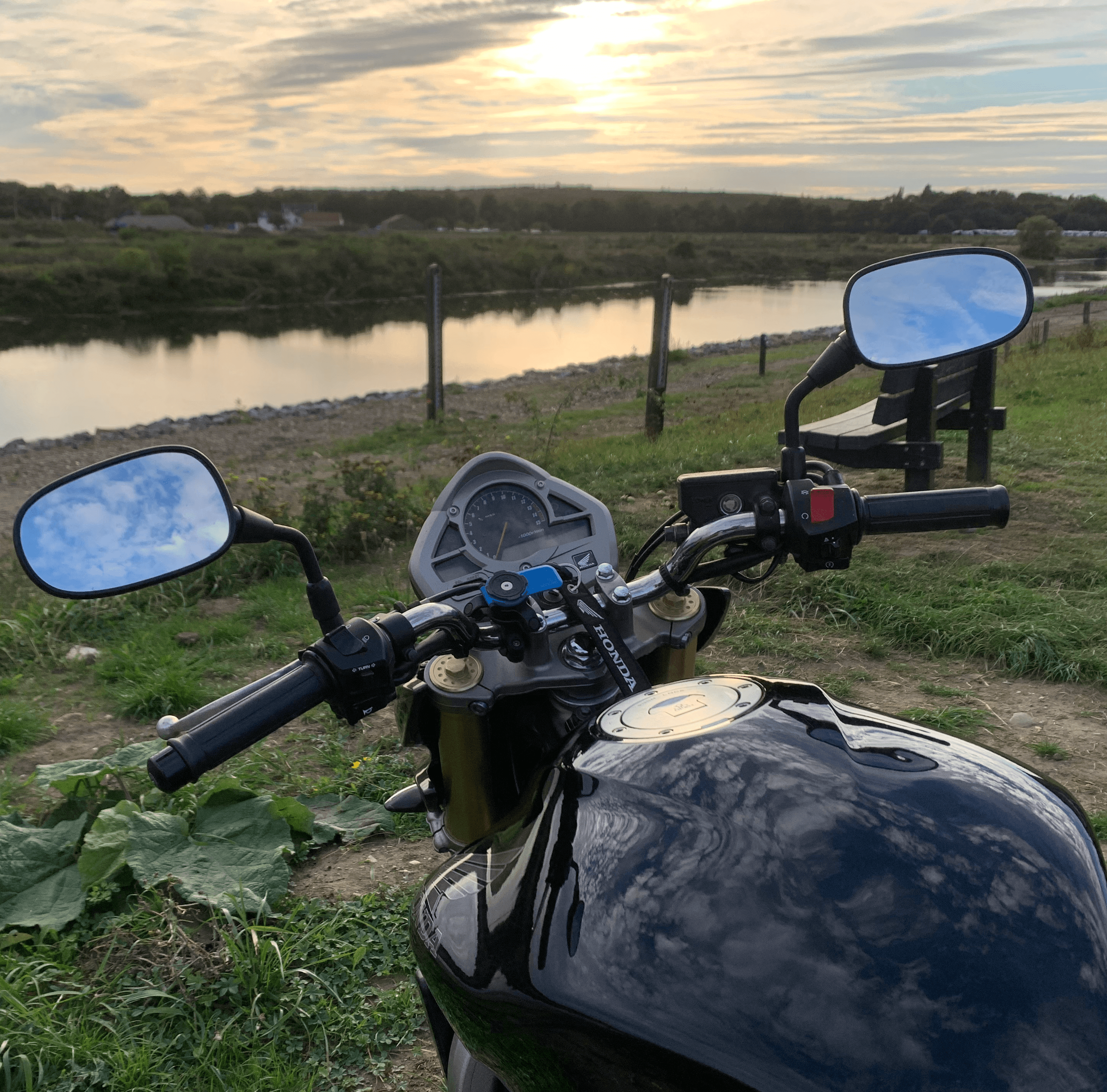A black motorcycle overlooking a green hillside.